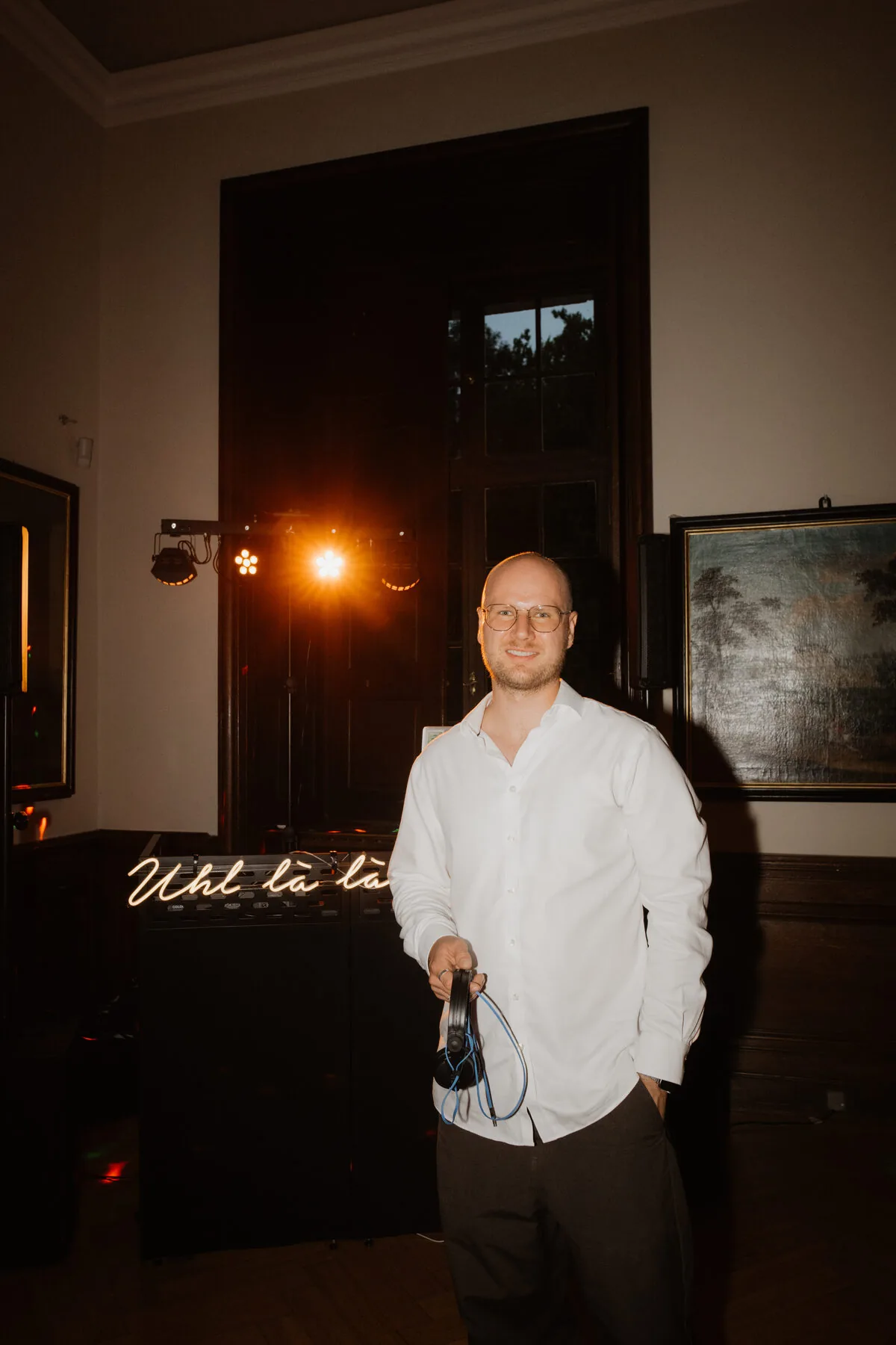 DJ Borris mit Kopfhörern vor seinem Equipment in historischem Saal